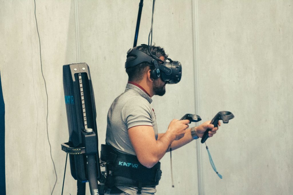 mann in grauem t-shirt und schwarzer hose hält schwarze dslr kamera und ist in der virtuellen Realität unterwegs