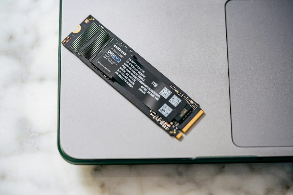 Eine Nahaufnahme eines Laptops auf einem Tisch mit einer SSD-Festplatte darauf 