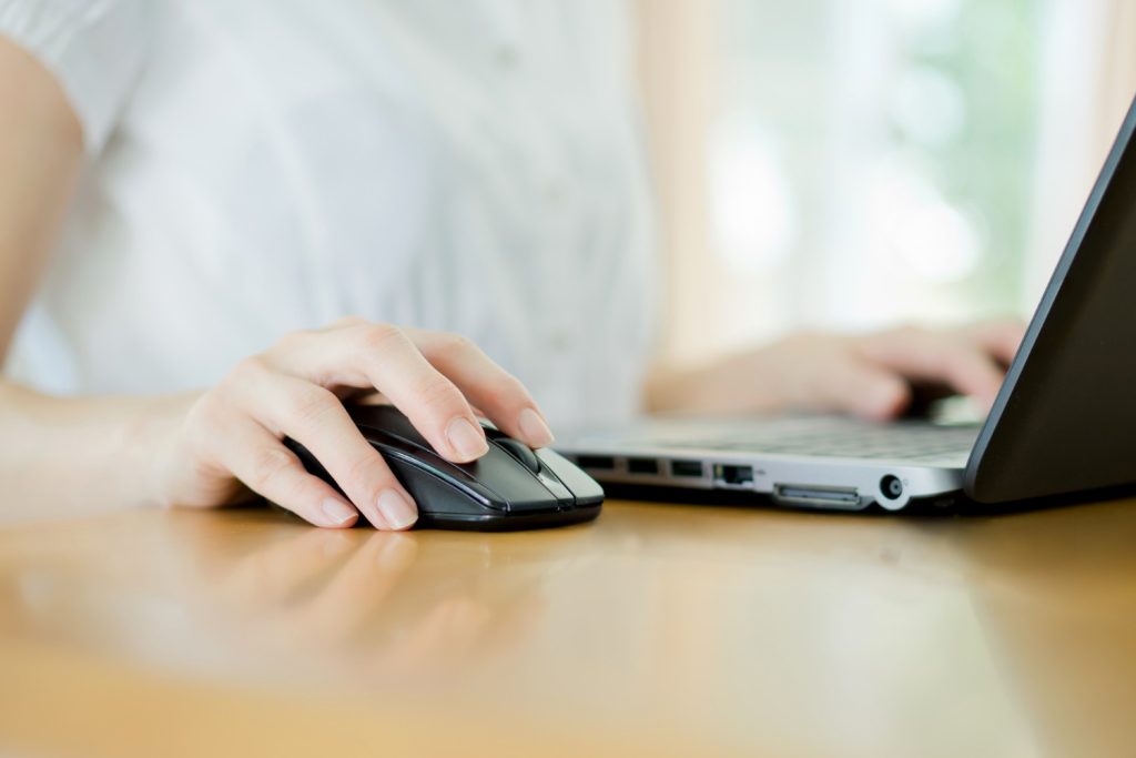 Frau sitzt am Laptop und nutzt Paypal 