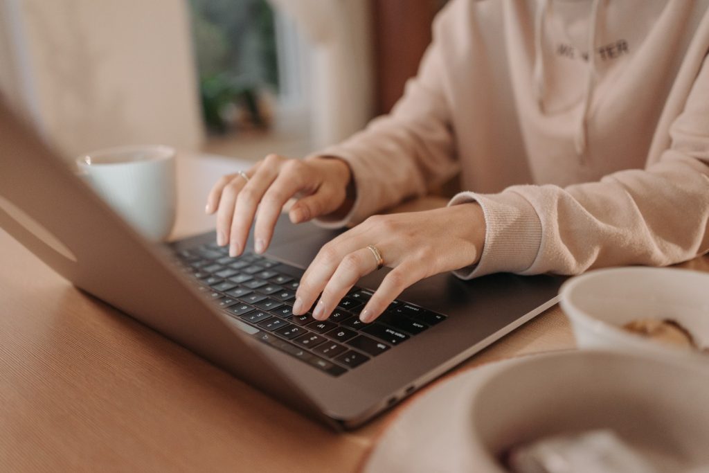 Frau sitzt am Laptop und ändert die PayPal Telefonnummer