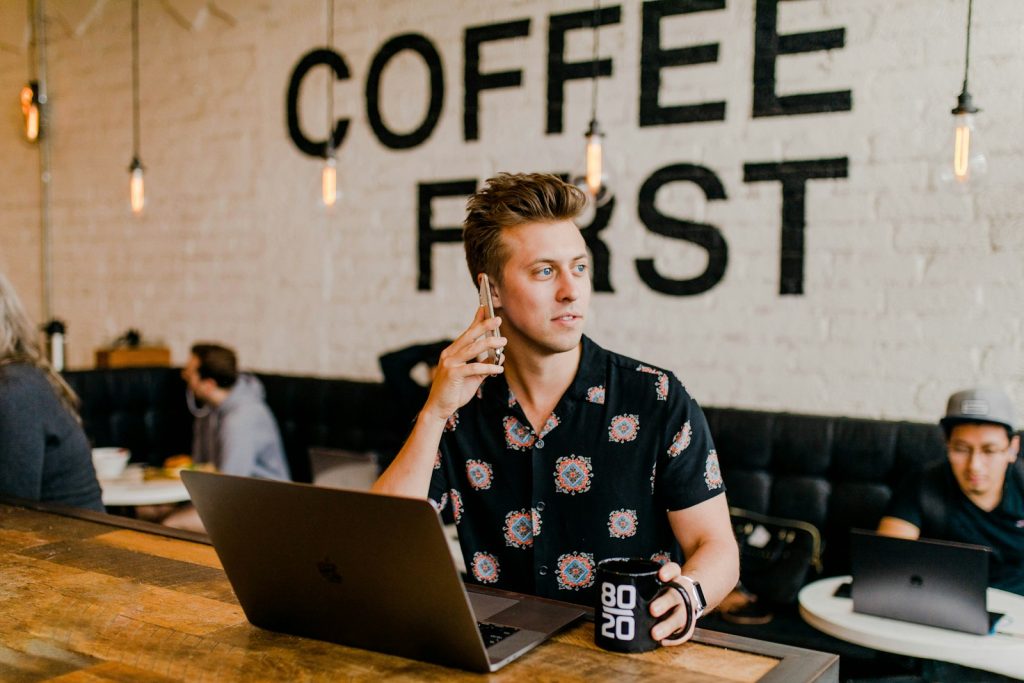 ein Key Account Manager hält ein Telefon weiß mit MacBook
