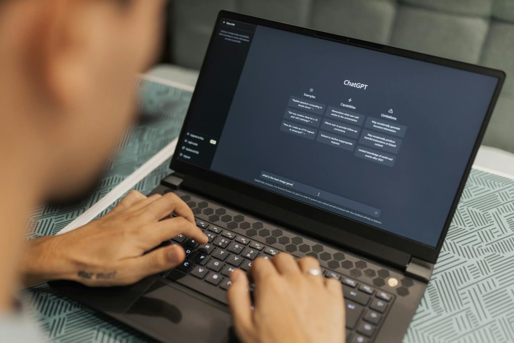 Nahaufnahme einer Person, die auf einem Laptop tippt und die ChatGPT-Oberfläche anzeigt, wobei die Nutzung moderner Technologie hervorgehoben wird.
