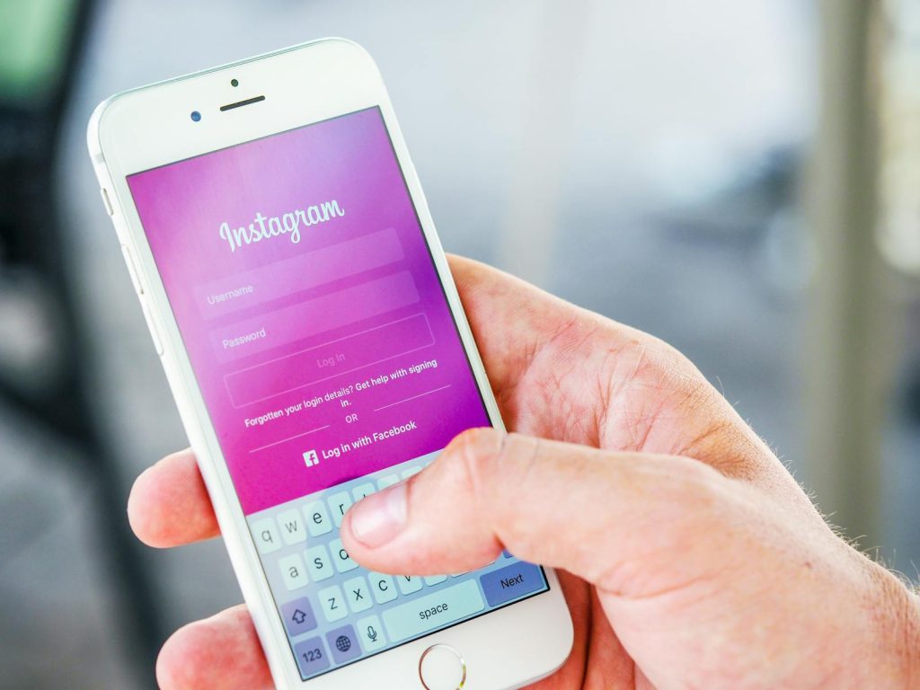 Nahaufnahme einer Hand, die ein Smartphone hält und den Instagram-Anmeldebildschirm anzeigt, der mobile Technologie hervorhebt.