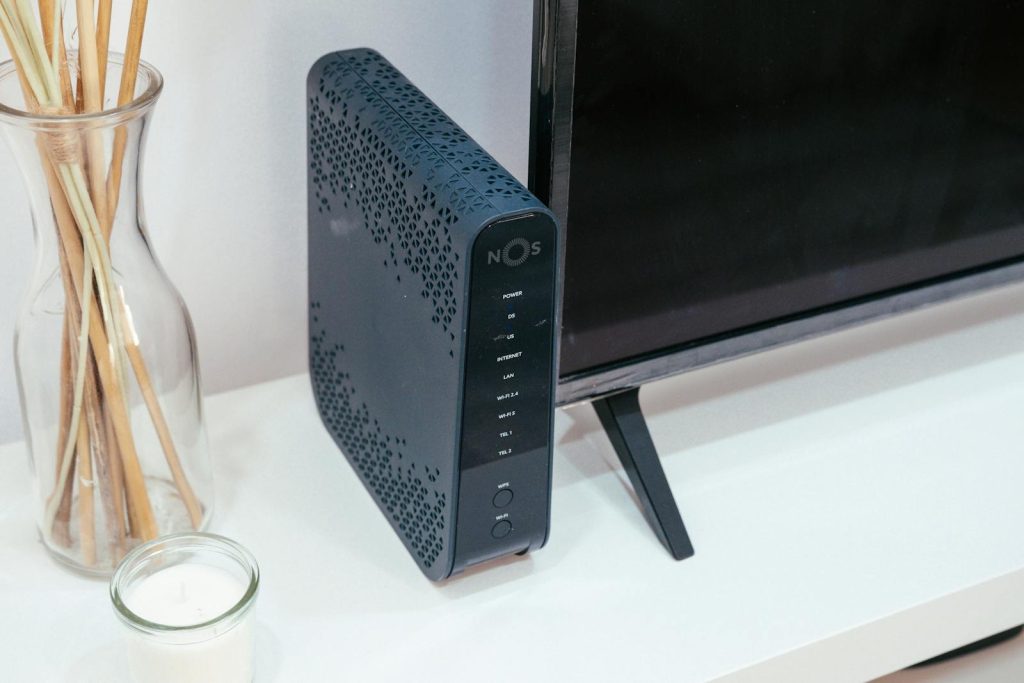 Ein elegantes Haustechnik-Setup mit Fritzbox, Glasdekoration und Fernseher.