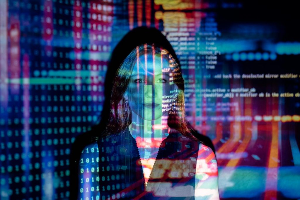 Eine Frau mit digitalen Codeprojektionen im Gesicht, die Technologie und Zukunftskonzepte repräsentieren.