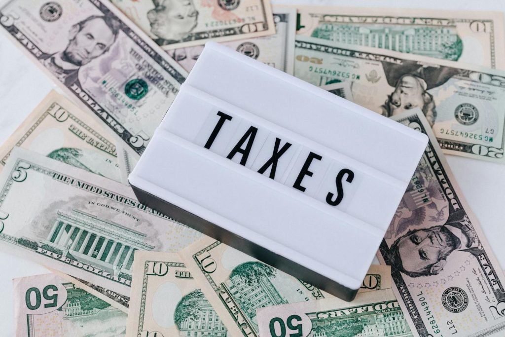US-Dollar-Scheine umgeben ein Schild mit der Aufschrift „STEUERN“. Ideal für 