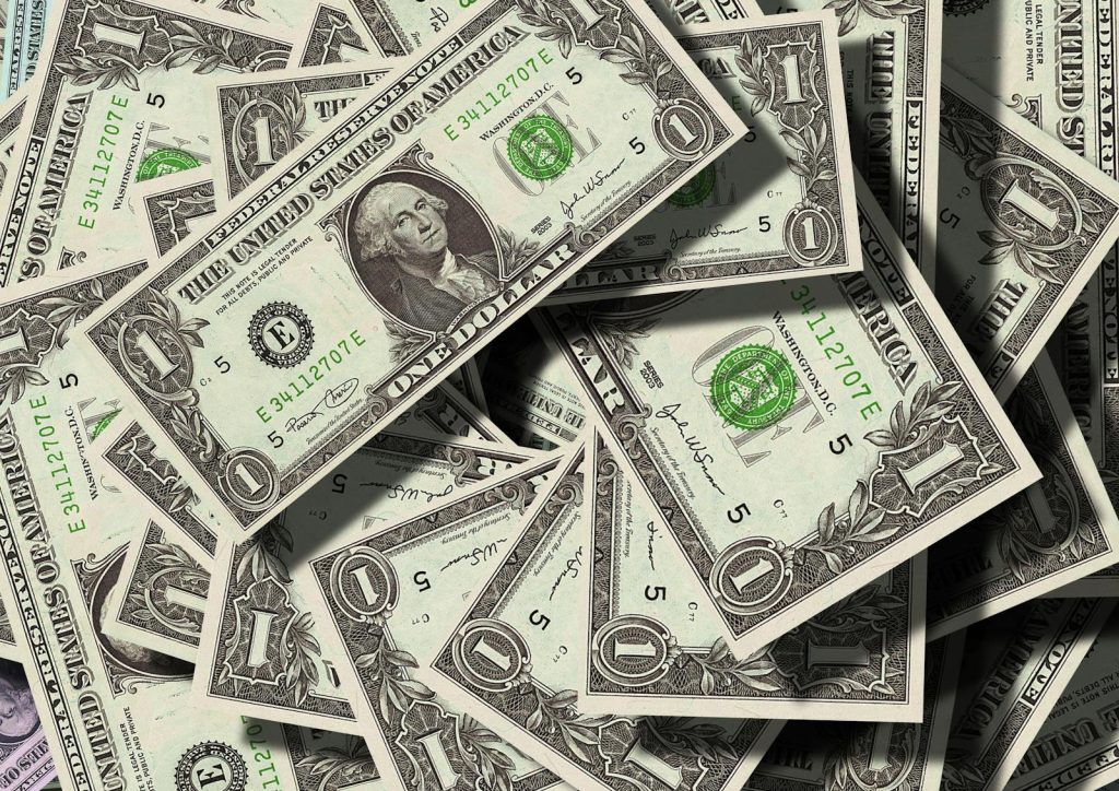 Nahaufnahme verstreuter US-Dollar-Scheine, die Finanzen und Reichtum symbolisieren.