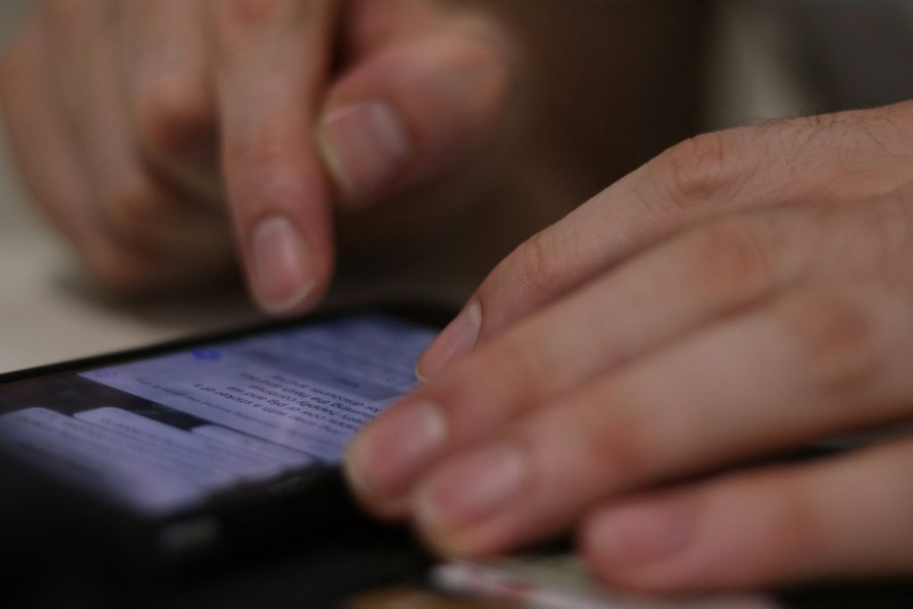 eine Nahaufnahme einer Person, die ein SMS schreibt