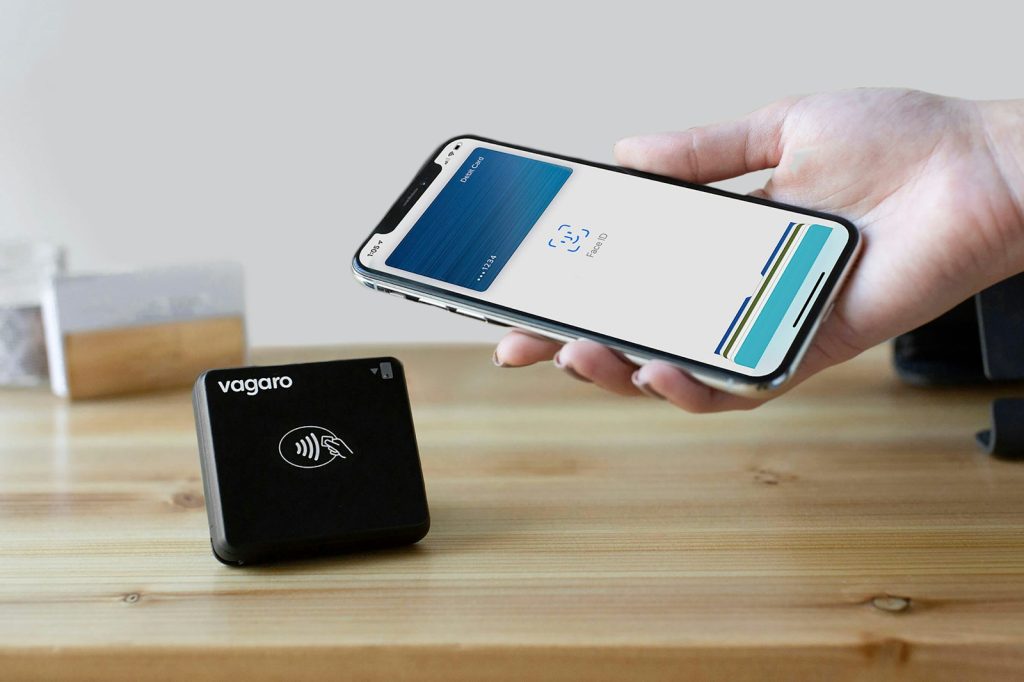 eine Person, die ein Mobiltelefon neben einem Ladegerät hält