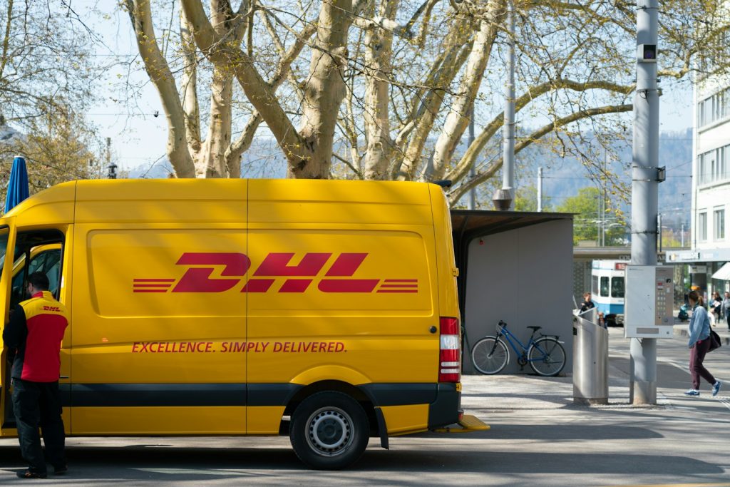 Mann steht vor der Tür eines DHL-Lkw