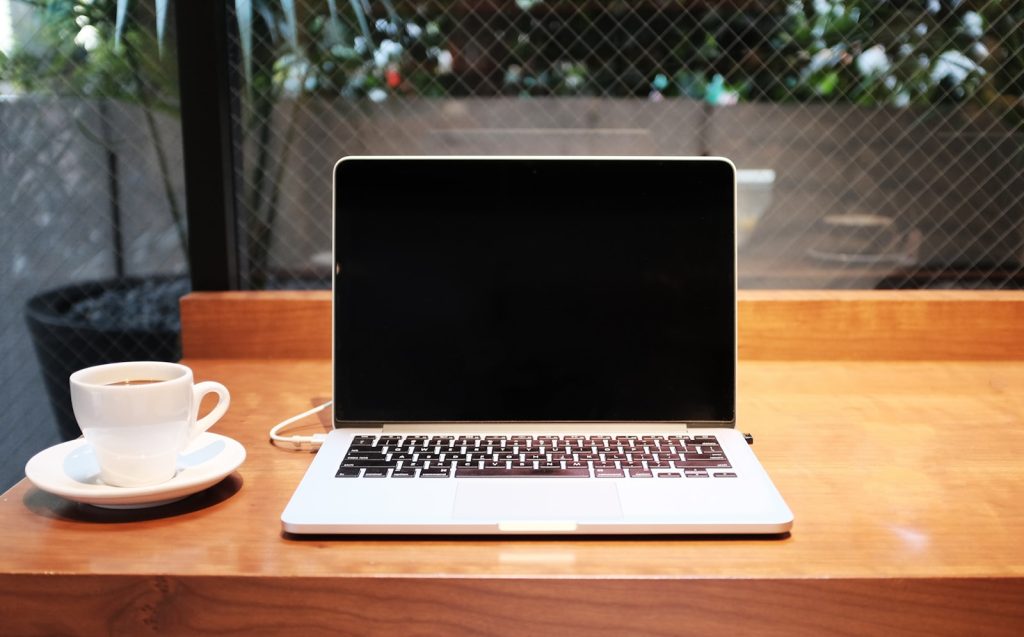 Laptop-Computer neben Kaffeetasse