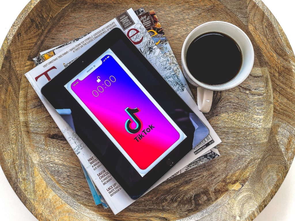 Ein Tablet mit TikTok Symbol. Daneben ein Kaffee