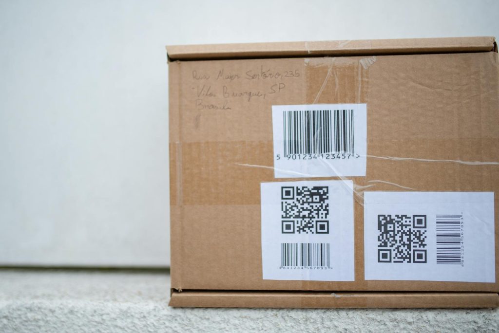 Nahaufnahme einer Kartonverpackung mit QR-Codes und einem Barcode, ideal für Liefer- und Versandkonzepte.