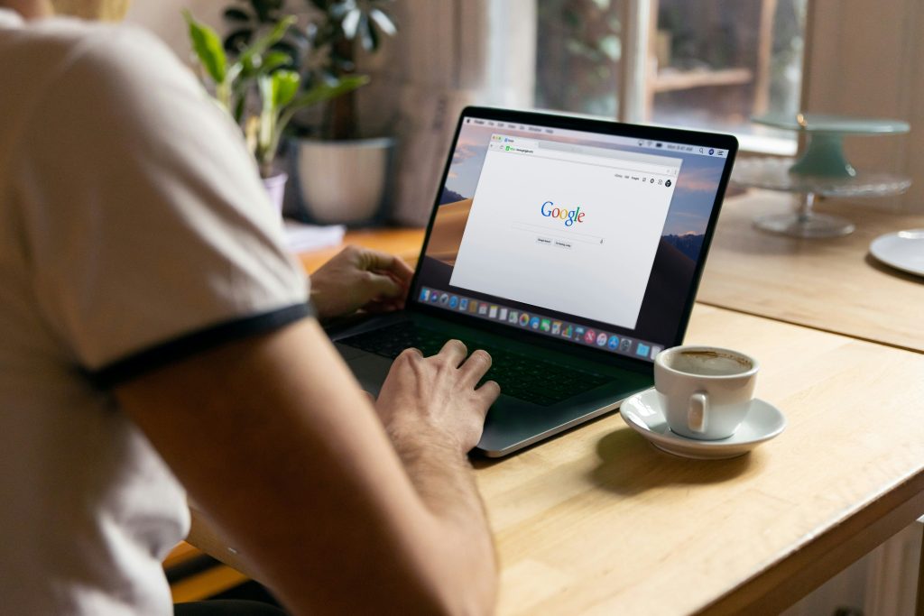 Mann sitzt am Laptop und googlet